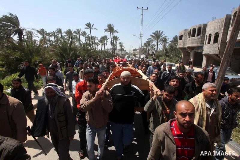 Palestinian mourners carry the bodies of three children who died the previous day in a domestic fire during their funeral in Deir al-Balah in the central Gaza Strip on April 02, 2012. The three Palestinian children, aged...