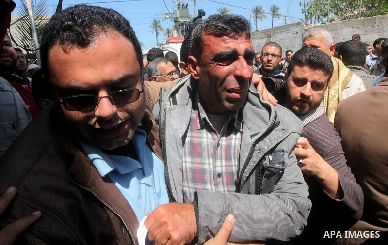 The father (C) of three Palestinian children who were killed the previous day in a domestic fire mourns during their funeral procession in Deir al-Balah in the central Gaza Strip on April 02, 2012. The three Palestinian...