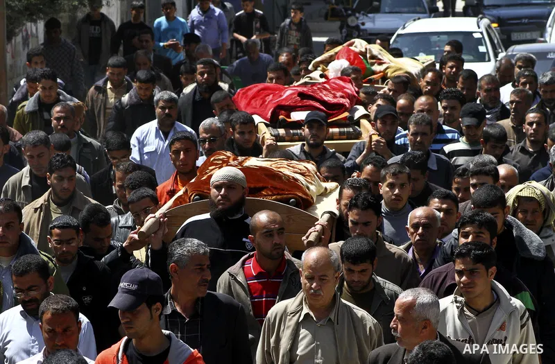 Palestinian mourners carry the bodies of three children who died the previous day in a domestic fire during their funeral in Deir al-Balah in the central Gaza Strip on April 02, 2012. The three Palestinian children, aged...
