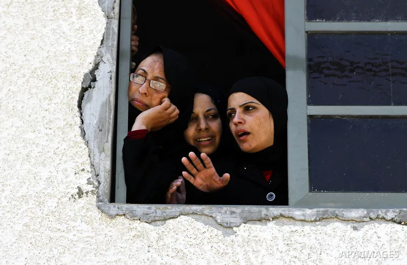 Palestinian relatives cry as mourners carry the bodies of three children who died in a domestic fire during their funeral during their funeral procession in Deir al-Balah in the central Gaza Strip on April 02, 2012. The...