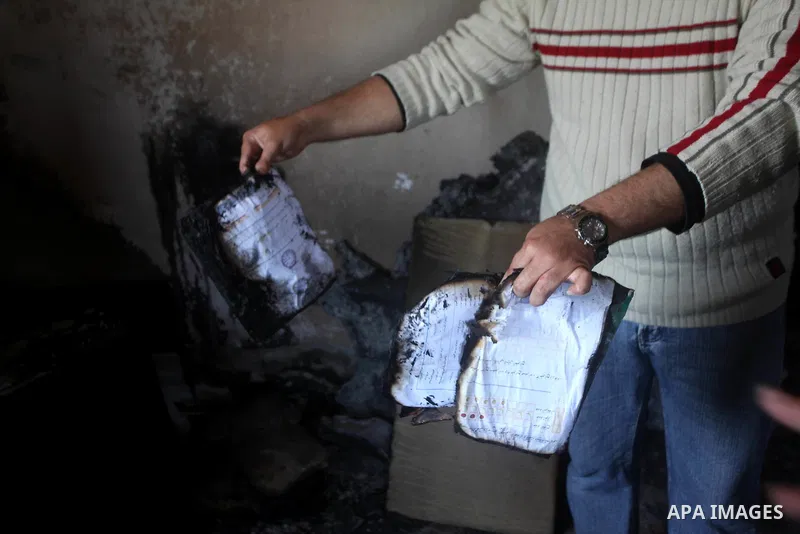 Palestinian men inspect on April 2, 2012 the damage in the bedroom of three children who were killed the previous day in a domestic fire in Deir al-Balah in the central Gaza Strip. The three Palestinian children, aged tw...