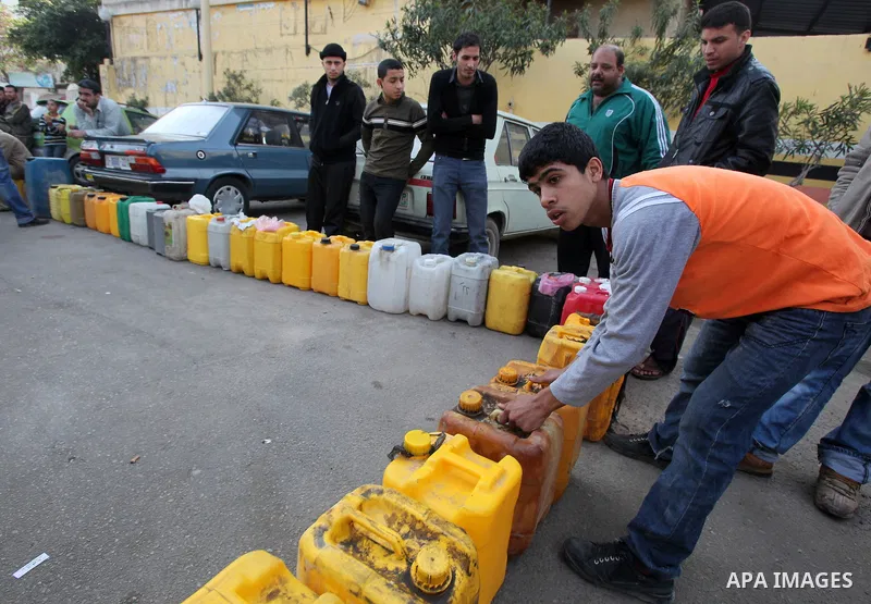 Palestinians wait in a queue to fill containers with fuel at a petrol station in Gaza City on April 2, 2012. The International Committee of the Red Cross (ICRC) began transferring emergency supplies of fuel to the Gaza S...