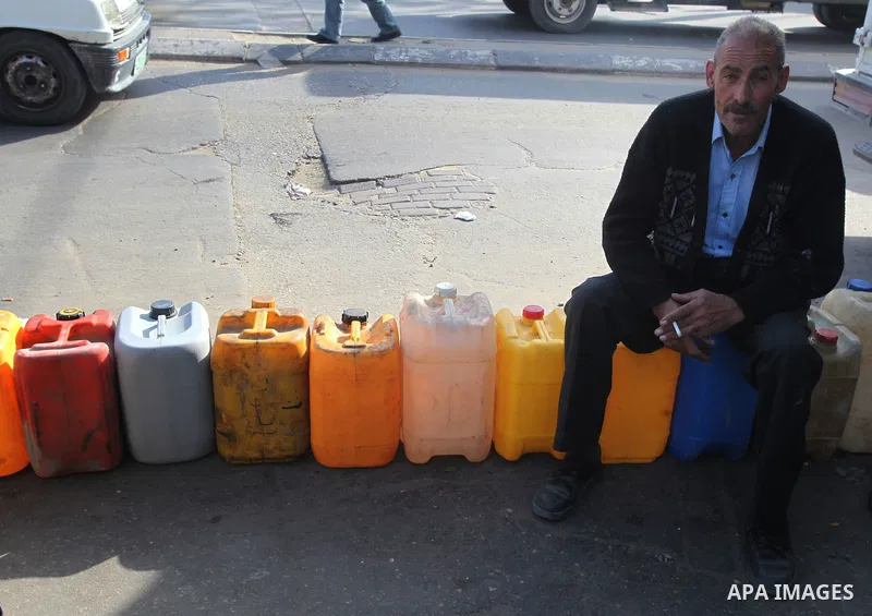 Palestinians wait in a queue to fill containers with fuel at a petrol station in Gaza City on April 2, 2012. The International Committee of the Red Cross (ICRC) began transferring emergency supplies of fuel to the Gaza S...