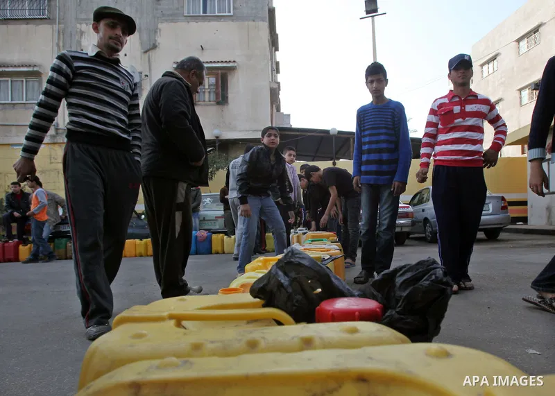 Palestinians wait in a queue to fill containers with fuel at a petrol station in Gaza City on April 2, 2012. The International Committee of the Red Cross (ICRC) began transferring emergency supplies of fuel to the Gaza S...