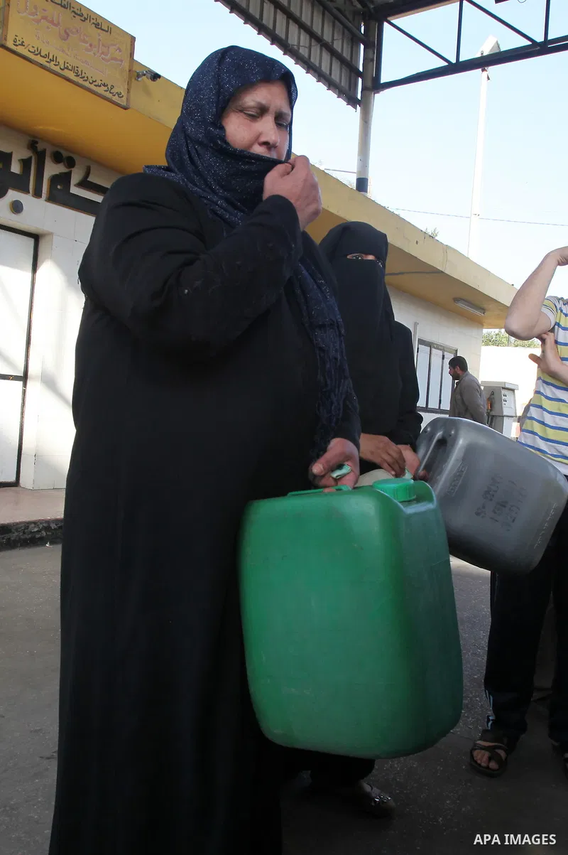 Palestinians wait in a queue to fill containers with fuel at a petrol station in Gaza City on April 2, 2012. The International Committee of the Red Cross (ICRC) began transferring emergency supplies of fuel to the Gaza S...