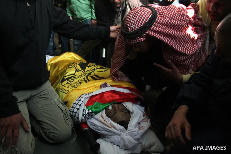 Palestinian mourns gather around the body of Rashad Deeb, who was shot and injured by Israeli troops along with his two brothers in the early hours of March 27 in an incident in Rammun village, 10 kilometres (six miles)...