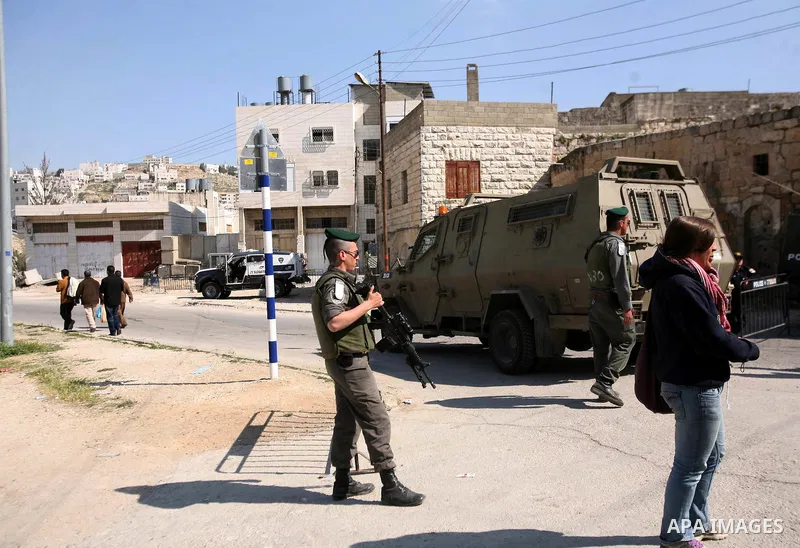 Israeli border police officers stand guard outside a building occupied by Jewish settlers in the West Bank city of Hebron April 3, 2012. Israeli Prime Minister Benjamin Netanyahu overruled the planned eviction on Tuesday...