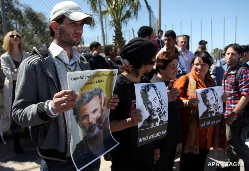 Dozens of Palestinians and foreigners, including artists, demonstrate in the West Bank city of Ramallah on April 4, 2012 to mark one year since the killing of Israeli-Palestinian theatre director Juliano Mer Khamis (port...