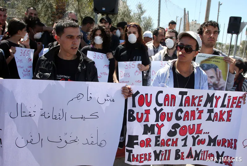 Dozens of Palestinians and foreigners, including artists, demonstrate in the West Bank city of Ramallah on April 4, 2012 to mark one year since the killing of Israeli-Palestinian theatre director Juliano Mer Khamis (port...