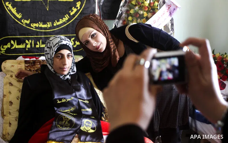 Palestinian visitors of Hanaa Shalabi , who spent 43 days on hunger strike in an Israeli prison, take her pictures with their mobile phones in Al-Quds hospital in Gaza City on Apr. 04, 2012. Shalabi, who had begun her hu...