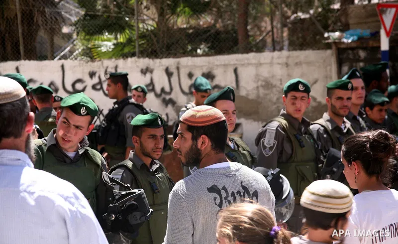 Jewish settlers stands near Israeli border policemen as they prevent her from reaching a building, occupied by Jewish settlers, in the West Bank city of Hebron April 4, 2012. Israeli police evicted Jewish settlers on Wed...
