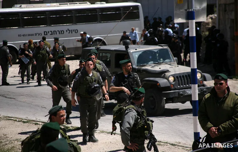 Jewish settlers stands near Israeli border policemen as they prevent her from reaching a building, occupied by Jewish settlers, in the West Bank city of Hebron April 4, 2012. Israeli police evicted Jewish settlers on Wed...