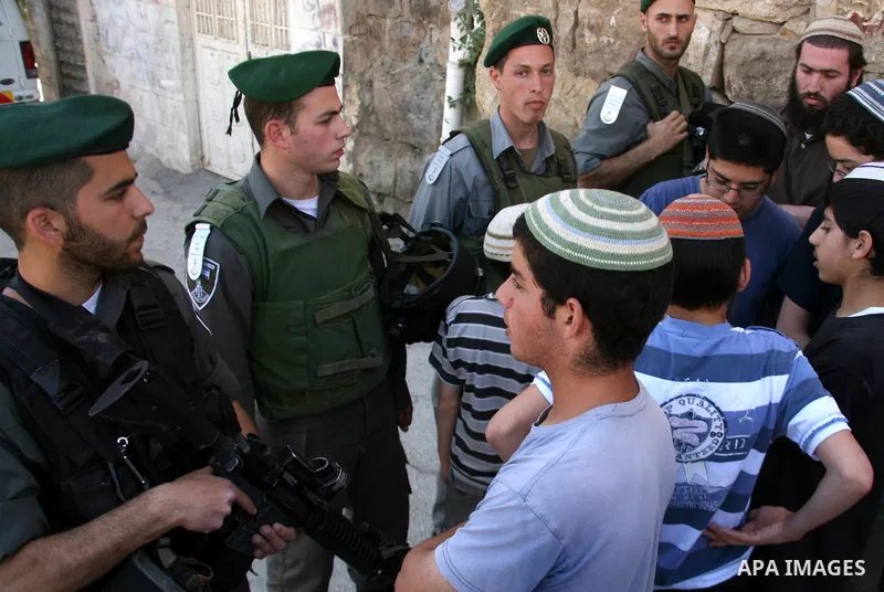 Jewish settlers stands near Israeli border policemen as they prevent her from reaching a building, occupied by Jewish settlers, in the West Bank city of Hebron April 4, 2012. Israeli police evicted Jewish settlers on Wed...