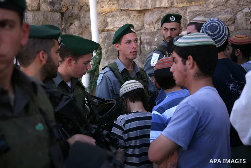 Jewish settlers stands near Israeli border policemen as they prevent her from reaching a building, occupied by Jewish settlers, in the West Bank city of Hebron April 4, 2012. Israeli police evicted Jewish settlers on Wed...