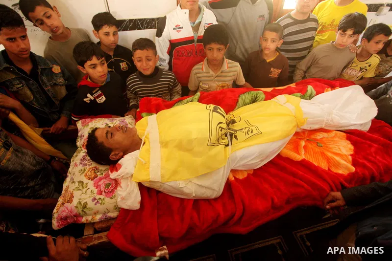 Palestinian children gather around the body of Palestinian youth Hashem Saed, 17-years-old, during his funeral in Gaza City on April 4, 2012, after he was shot overnight close along the border fence between the Gaza Stri...