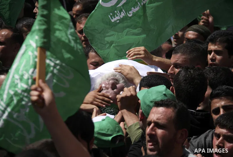 Palestinian mourners gather around the body of Sheikh Hamed Al-Betawi member of the Legislative Council for Hamas during his funeral in the West Bank city of Thursday, April 5, 2012 . Photo by Wagdi Eshtayah