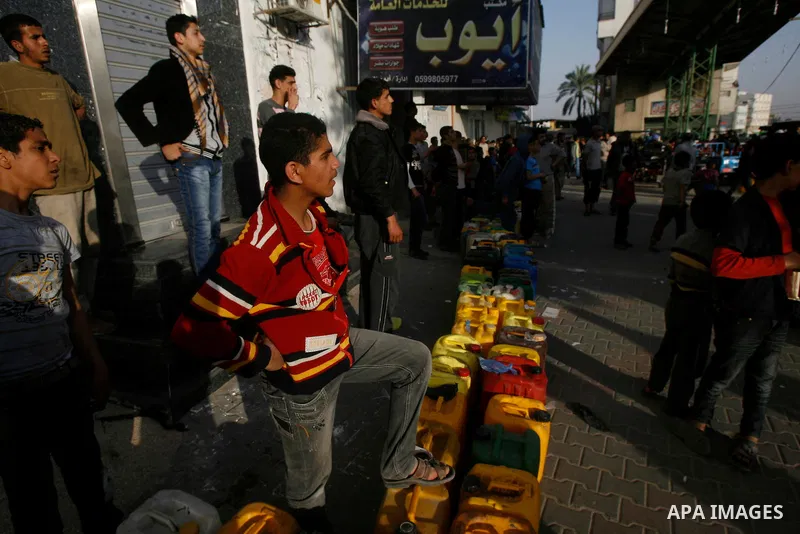 Palestinians wait to fill fuel containers from a petrol station in Rafah in the southern Gaza Strip, 05 April 2012. Reports state that residents in the Gaza Strip flocked to petrol stations hoping to get a share of the r...