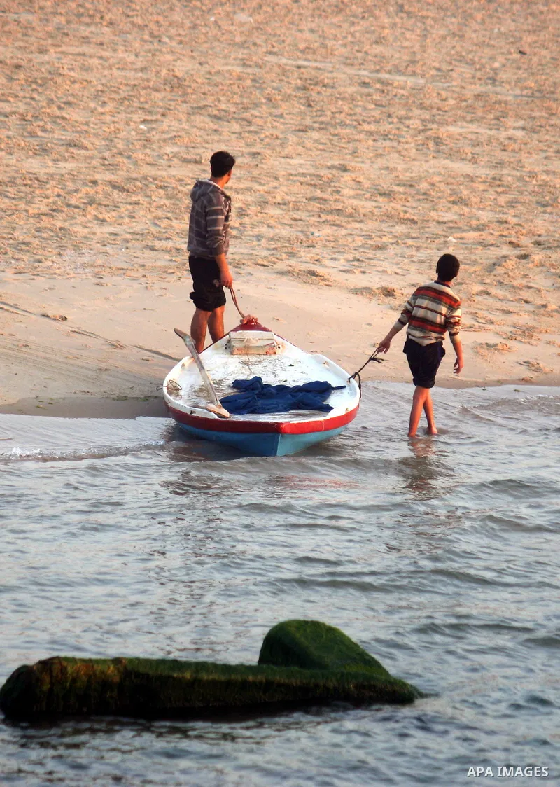 Palestinian fishermen pull their boat at the beach during sunset of Gaza city, 06 April 2012. Photo by Emad Nassar