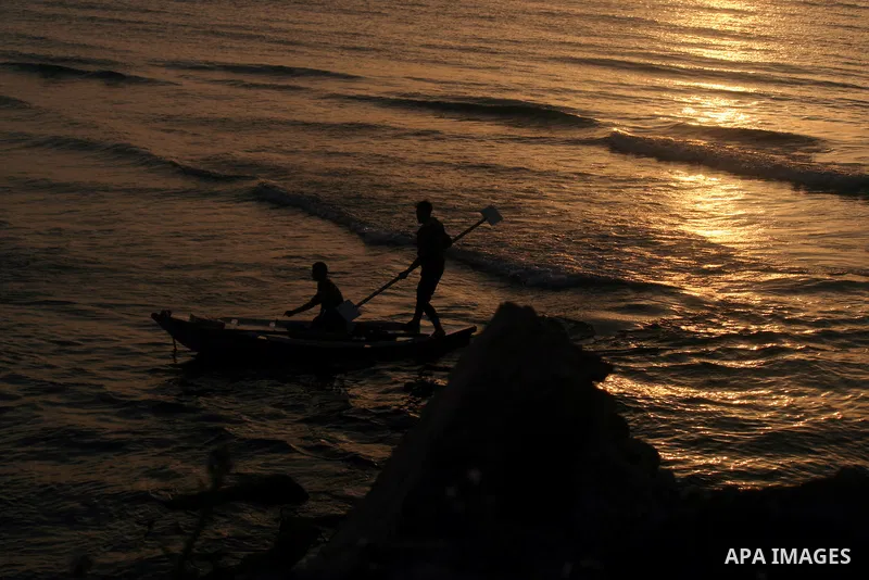 Palestinian fishermen are seen silhouetted on their boat in the Mediterranean sea during sunset to the West of Gaza city, 06 April 2012. Photo by Emad Nassar