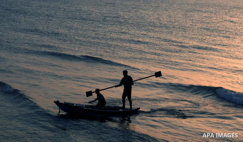 A Palestinian fisherman is seen silhouetted on his boat on the Mediterranean sea after sunset in the West of Gaza city on 06 April 2012. Photo by Emad Nassar