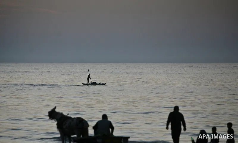 Palestinian fishermen are seen silhouetted on their boat in the Mediterranean sea during sunset to the West of Gaza city, 06 April 2012. Photo by Ali Jadallah