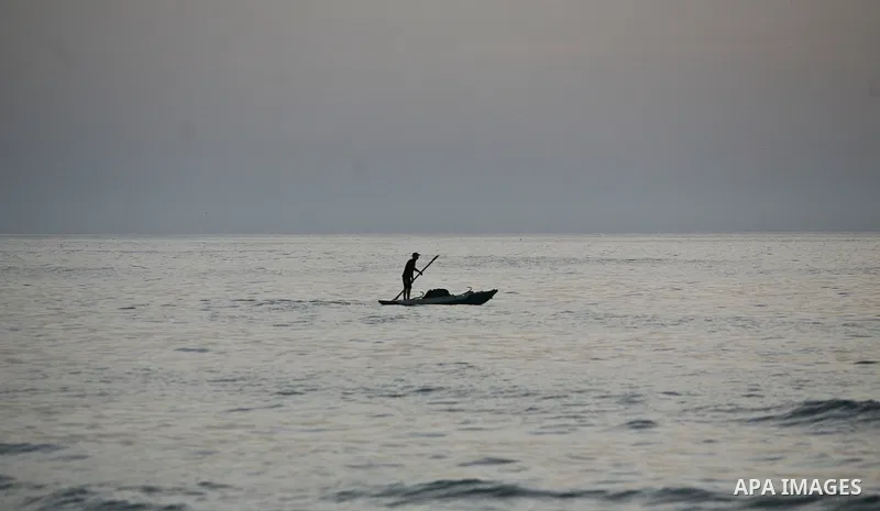 Palestinian fishermen are seen silhouetted on their boat in the Mediterranean sea during sunset to the West of Gaza city, 06 April 2012. Photo by Ali Jadallah