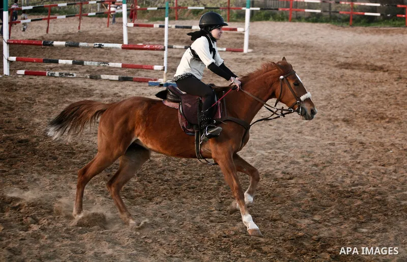 A Palestinian child rides a horse during a championship at Gaza Horse Club in Gaza Strip, 06 April 2012. The clubs is home to some 54 horses and open for the training of male and female children aged between 12 to 23 yea...