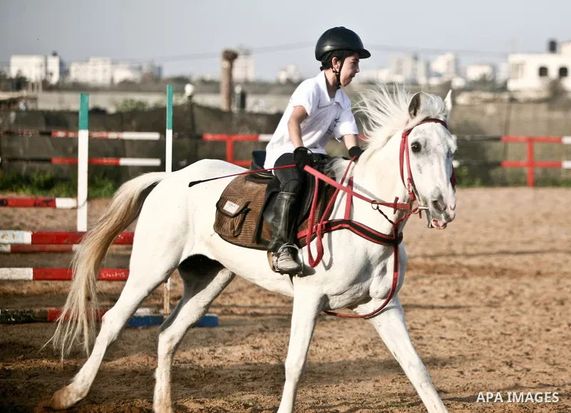 A Palestinian child rides a horse during a championship at Gaza Horse Club in Gaza Strip, 06 April 2012. The clubs is home to some 54 horses and open for the training of male and female children aged between 12 to 23 yea...