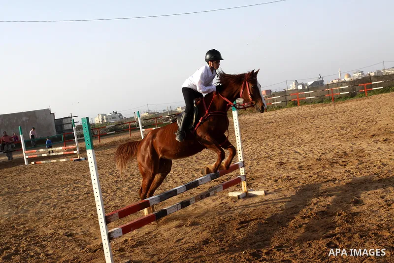 A Palestinian boy rides a horse during a championship at Gaza Horse Club in Gaza Strip, 06 April 2012. The clubs is home to some 54 horses and open for the training of male and female children aged between 12 to 23 years...