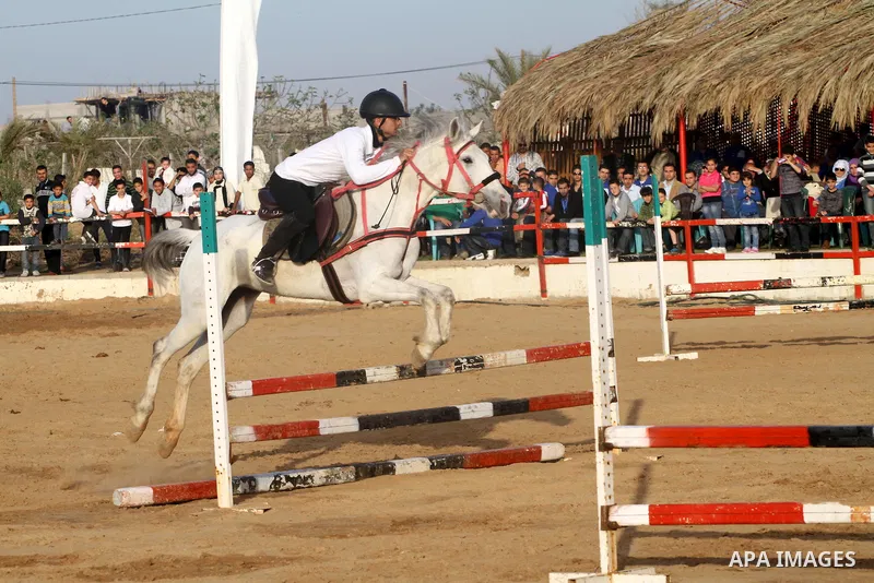 A Palestinian boy rides a horse during a championship at Gaza Horse Club in Gaza Strip, 06 April 2012. The clubs is home to some 54 horses and open for the training of male and female children aged between 12 to 23 years...