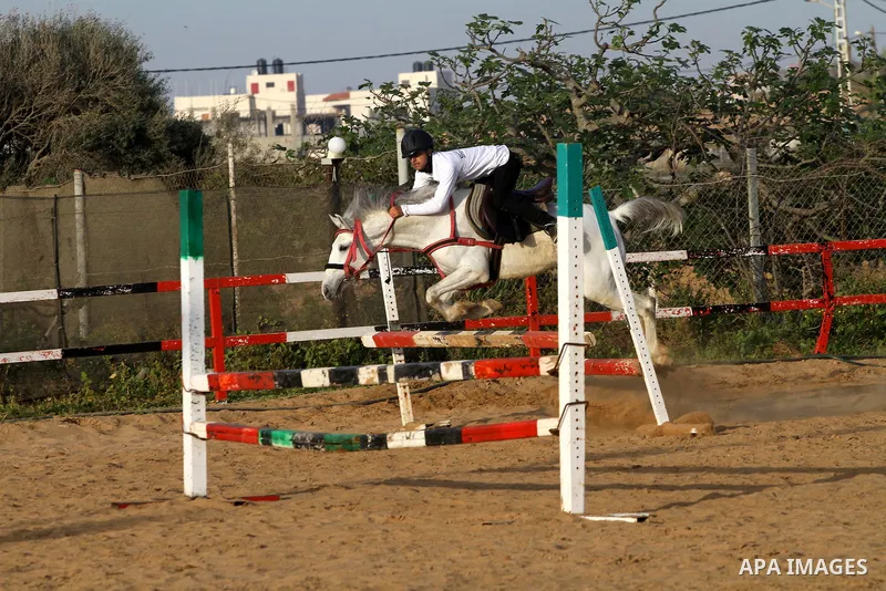 A Palestinian boy rides a horse during a championship at Gaza Horse Club in Gaza Strip, 06 April 2012. The clubs is home to some 54 horses and open for the training of male and female children aged between 12 to 23 years...