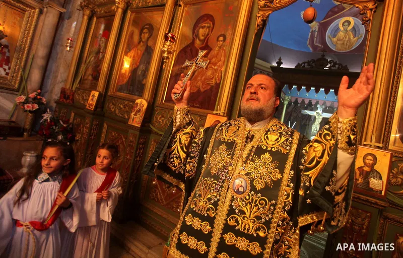 An Orthodox priest leads a Palm Sunday mass at the Saint Porfirios church in Gaza City April 8, 2012. Photo by Ashraf Amra
