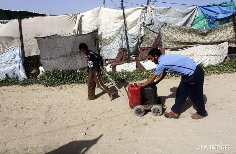 Palestinians refilling plastic bottles and jerry cans from fuel in a poor region of the Al-Nusairat neighborhood, central Gaza Strip on 08 April 2012. Photo by Ashraf Amra