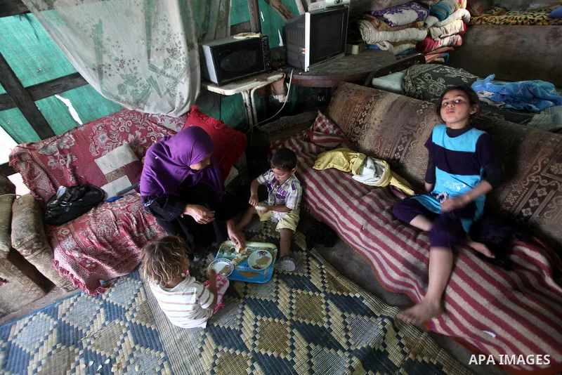 A Palestinian family eating inside his family house in a poor region of the Al-Nusirat neighborhood, central Gaza Strip on 08 April 2012. Reports from the World Bank on 06 April 2012 state that The World Banks Board of...