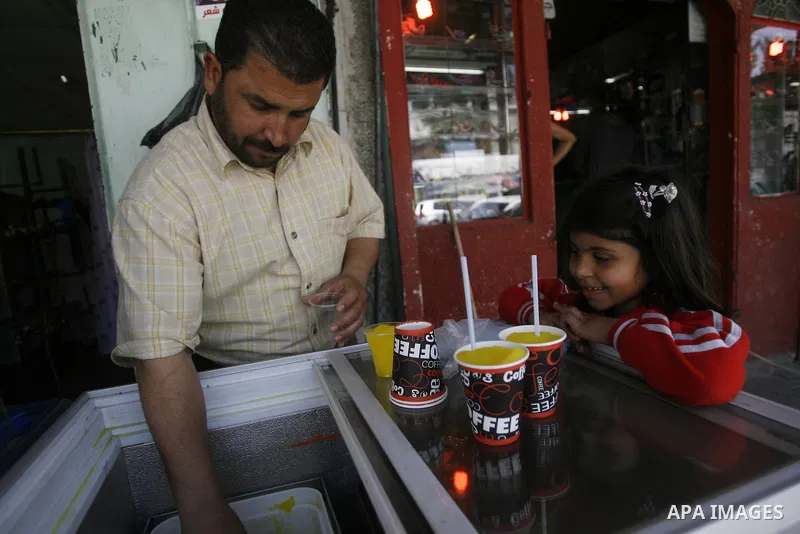 A Palestinian girl buys ice cream in the market in the southern Gaza Strip refugee camp of Rafah, in Apr. 08, 2012. Photo by Eyad Al Baba