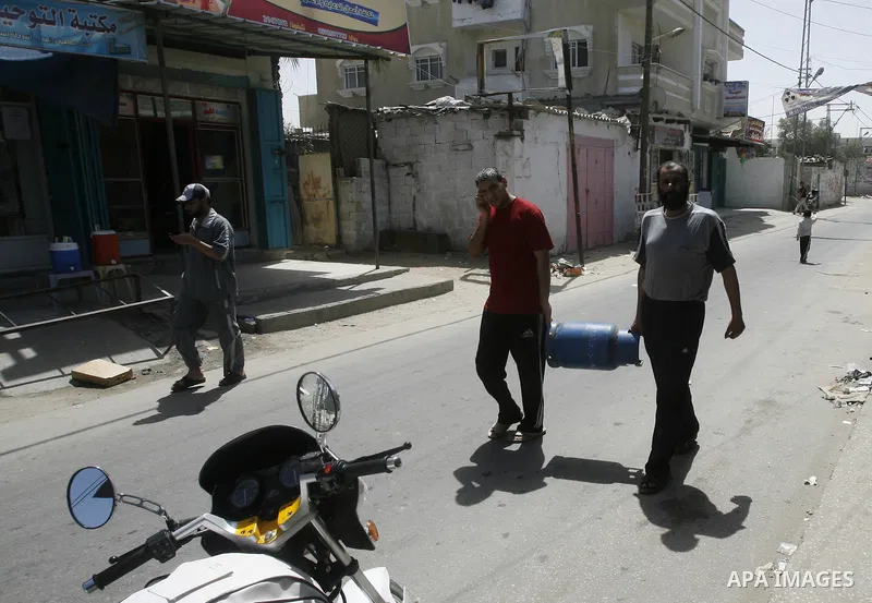 Palestinians carry gas cylinder is empty in the southern Gaza Strip refugee camp of Rafah, in Apr. 08, 2012. Photo by Eyad Al Baba