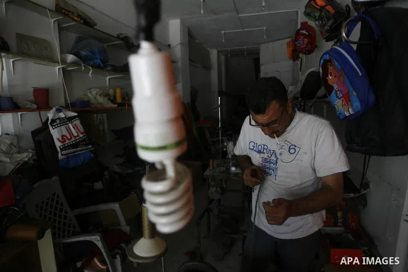 A Palestinian tailor sews of the school bags in his shop in the southern Gaza Strip refugee camp of Rafah, in Apr. 08, 2012. Photo by Eyad Al Baba