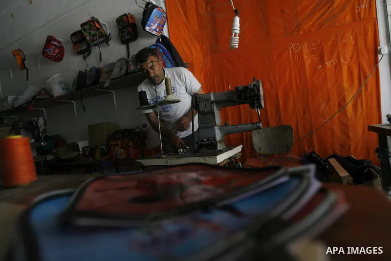 A Palestinian tailor sews of the school bags in his shop in the southern Gaza Strip refugee camp of Rafah, in Apr. 08, 2012. Photo by Eyad Al Baba