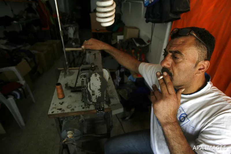 A Palestinian tailor sews of the school bags in his shop in the southern Gaza Strip refugee camp of Rafah, in Apr. 08, 2012. Photo by Eyad Al Baba