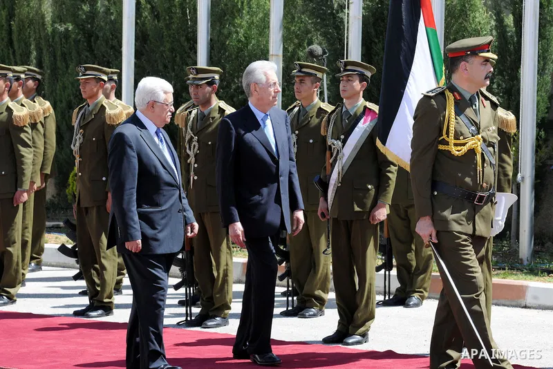 Palestinian President Mahmoud Abbas, meets with Italy's Prime Minister Mario Monti past an honour guard during a welcoming ceremony in the West Bank city of Ramallah April 8, 2012. Photo by Thaer Ganaim