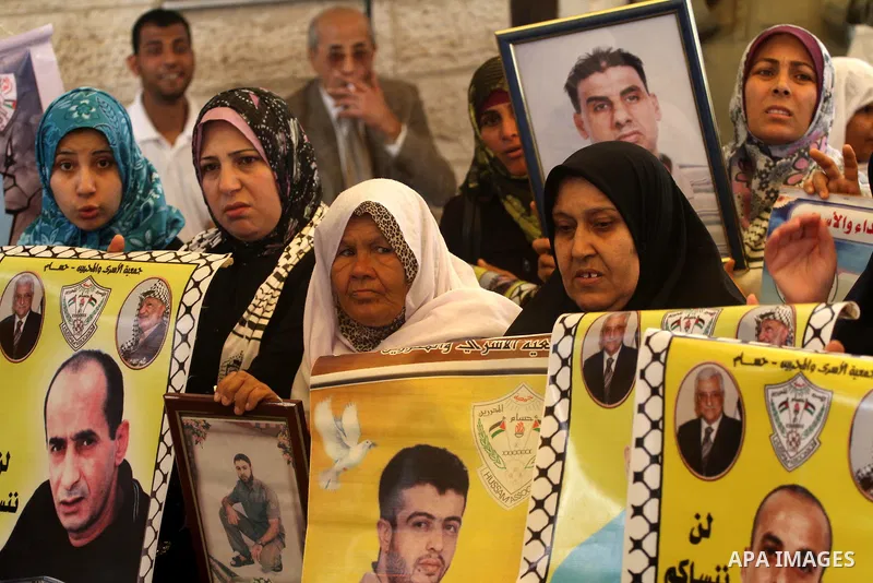 Palestinians hold pictures of their prisoned relatives in Israeli jails as they gather in a weekly activity calling for their liberty at the Red Cross headquarters in Gaza City on Apr. 09, 2012. Photo by Mohammed Asad