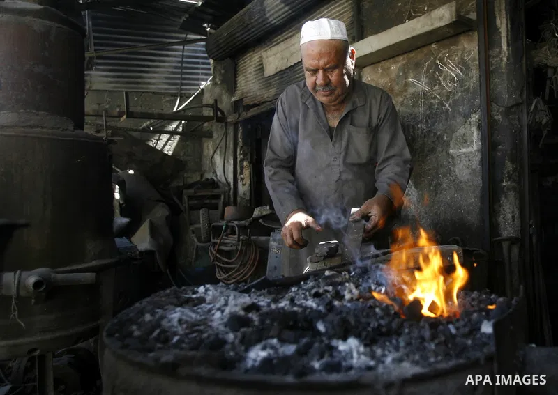 A Palestinian man works at a metal workshop in Rafah, southern Gaza Strip on April 10, 2012. Gaza has been in the grip of a severe power crisis for months now, with its sole electricity plant unable to function because o...