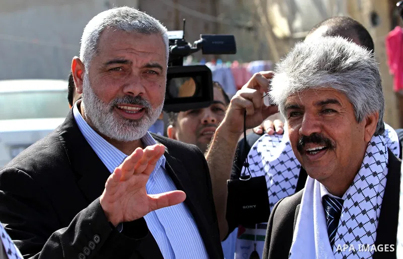 Palestinian Prime Minister in Gaza Strip, Ismail Haniya speaks with the Head of the Bahrani delegation during their tour to al-Shatea refugee camp in Gaza city on April 11,2012. The Bahrani delegation is in an official v...