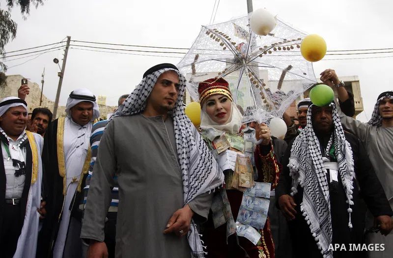 The Palestinian bride and groom Mhaha Salam (R) and Thayer Qasem (L), walk down the street on their wedding day on April 12, 2012 after they traveled from the refugee camp of al-Yarmuk in Syria, to get married in the Wes...