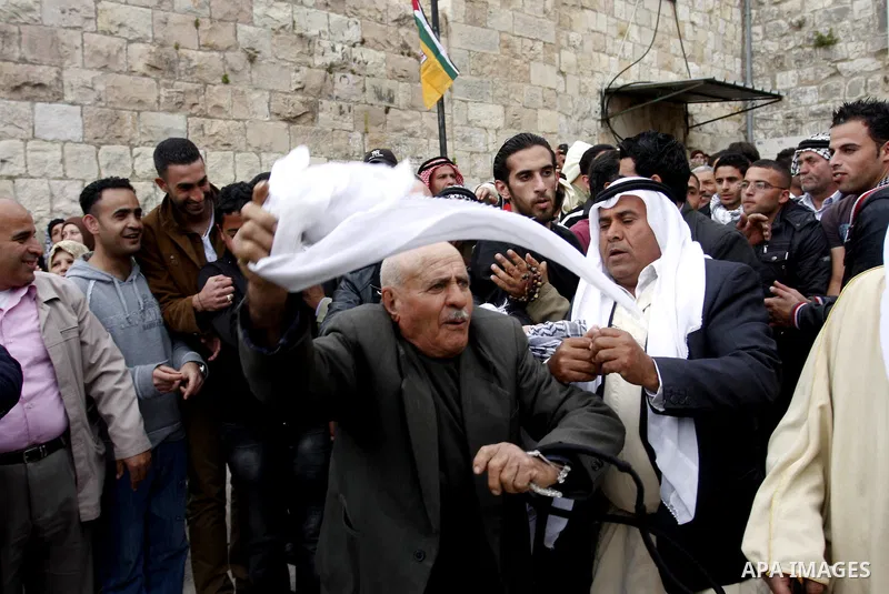 Palestinian celebrates during the wedding of the Palestinian bride and groom Maha Salam (unseen) and Thayer Qasem (unseen) in Deir Istia village the West Bank city of Nablus, on April 12, 2012. The newlyweds traveled fro...