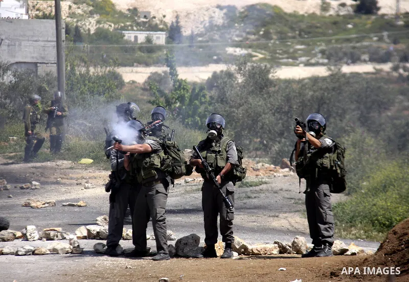 An Israeli soldier fires tear gas during clashes with Palestinians at a demonstration against the expropriation of Palestinian land by Israel in the village of Kfar Qaddum, near the West Bank city of Nablus, on April 13,...