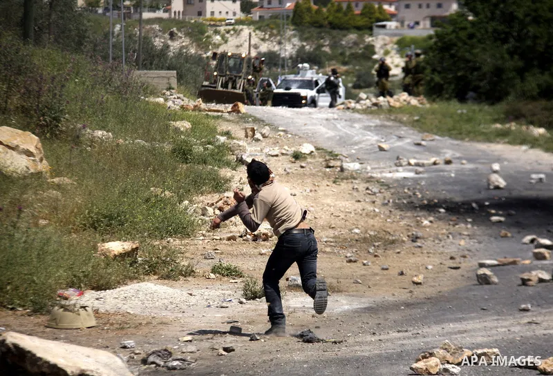 Palestinian protesters throw stones at Israeli soldiers during clashes following a demonstration against the expropriation of Palestinian land by Israel in the village of Kfar Qaddum, near the West Bank city of Nablus, o...