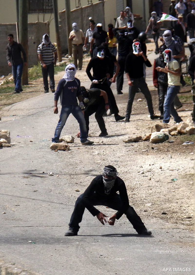 Palestinian protesters throw stones at Israeli soldiers during clashes following a demonstration against the expropriation of Palestinian land by Israel in the village of Kfar Qaddum, near the West Bank city of Nablus, o...
