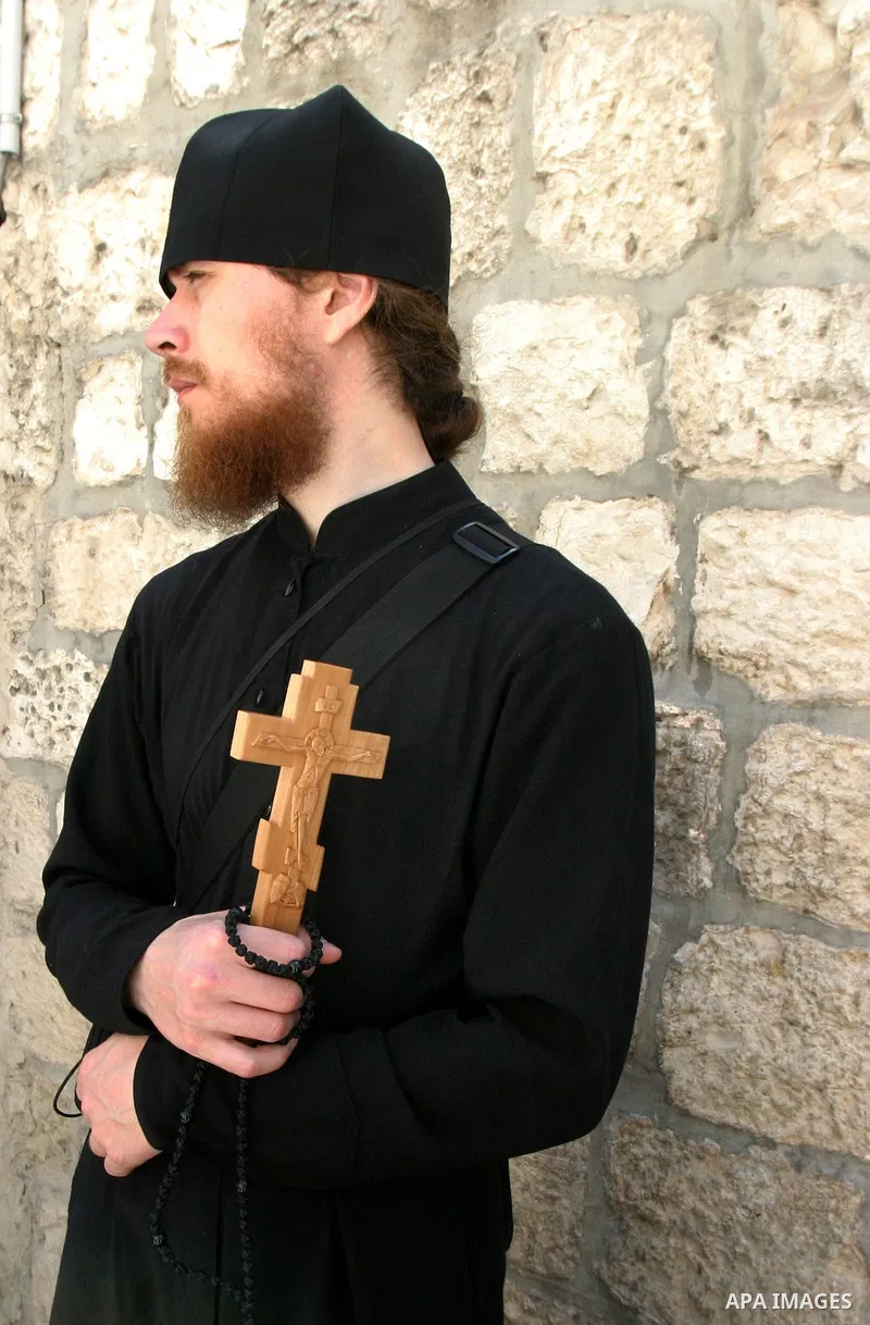 A Christian worshipper holds a cross in the Church of the Holy Sepulchre during the Eastern and Orthodox Church's Good Friday procession in the Old City of Jerusalem April 13, 2012. Photo by Mahfouz Abu Turk