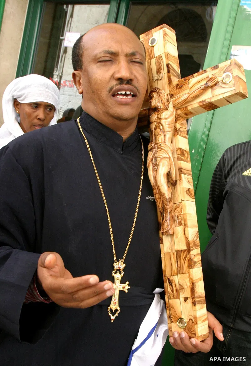 A Christian worshipper holds a cross in the Church of the Holy Sepulchre during the Eastern and Orthodox Church's Good Friday procession in the Old City of Jerusalem April 13, 2012. Photo by Mahfouz Abu Turk